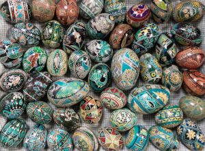 a selection of pysanky, or batik-dyed eggs, on plaid fabric